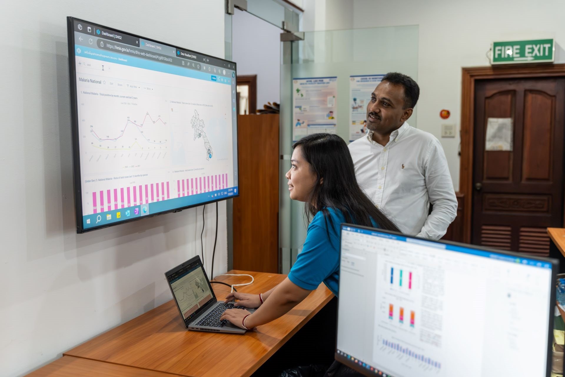 Two WHO staff members review maternal health data.